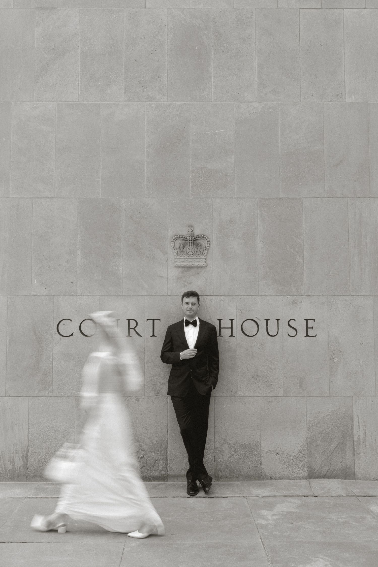 Bride and groom walking through grand marble courthouse hallway columns.