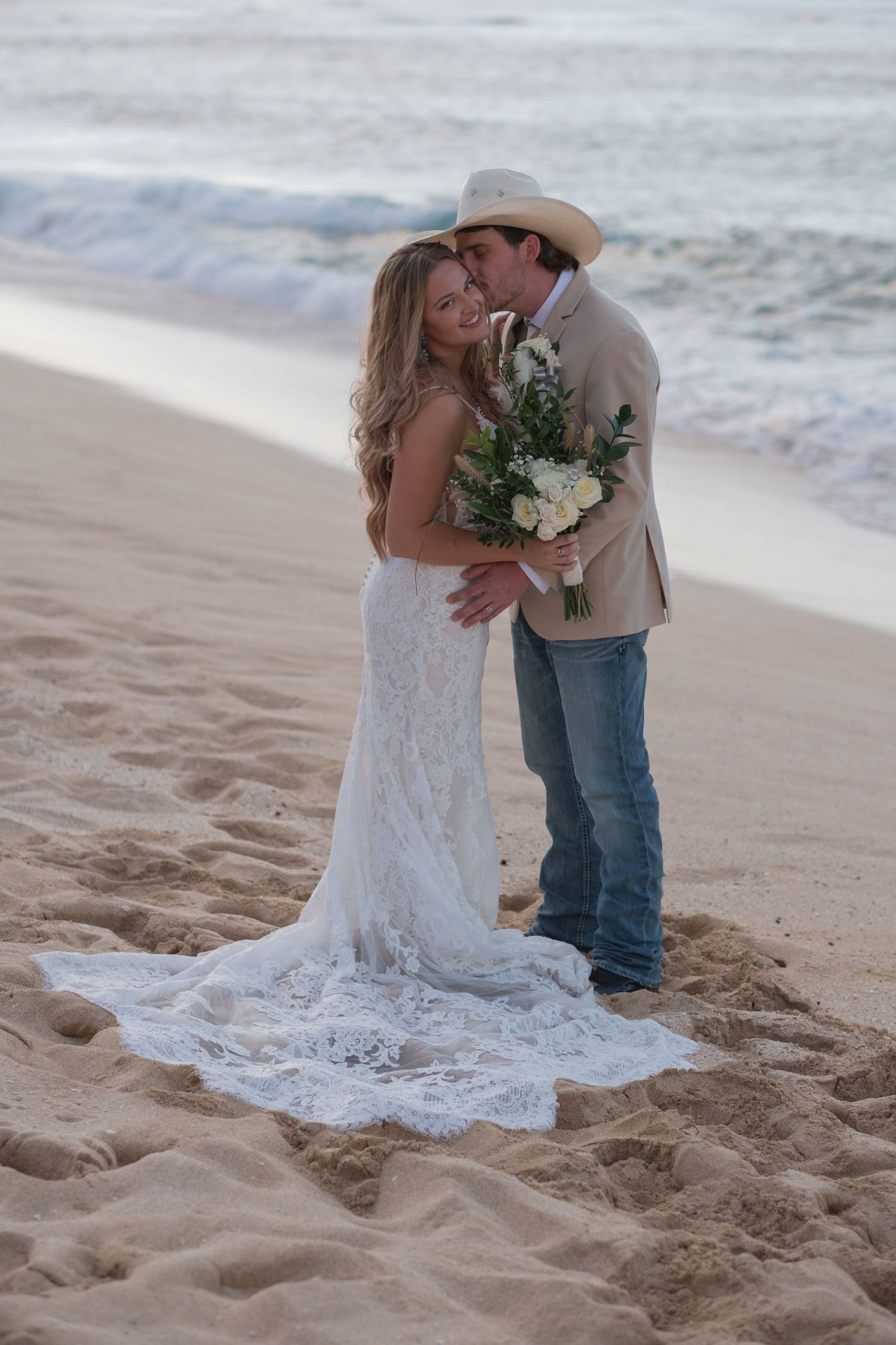 Bride and groom embracing on a North Shore Oahu beach during an intimate elopement photography session.