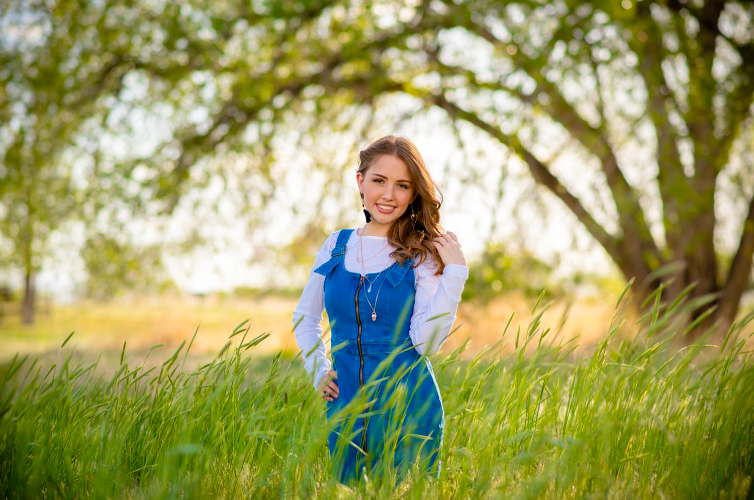 Spring portrait session in a lush green field with natural sunlight.