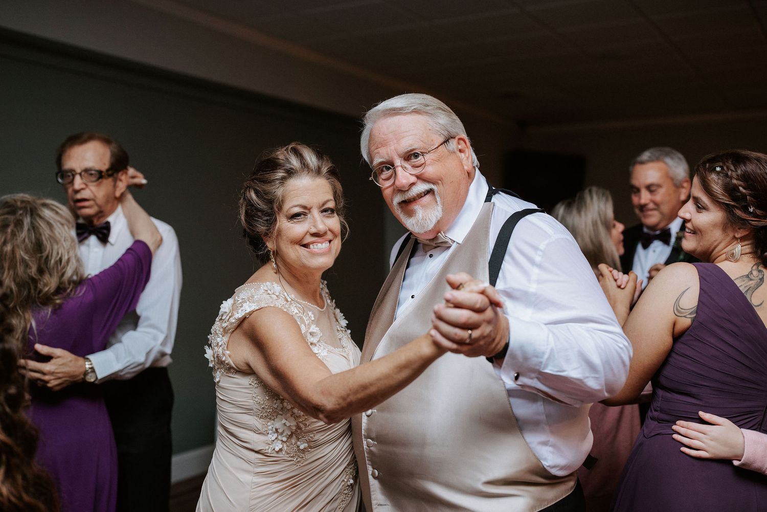 A couple shares an intimate dance moment in formal wedding attire, captured in a series of black and white photographs.