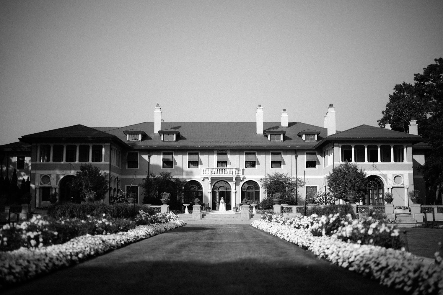 Dancing couple surrounded by elegant white pillars and grand wooden doors of a historic government building.