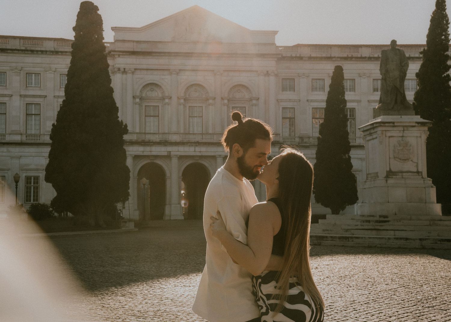 Couple in a Lisbon courtyard with arched walkways and lush garden landscaping at a historic museum in Portugal.