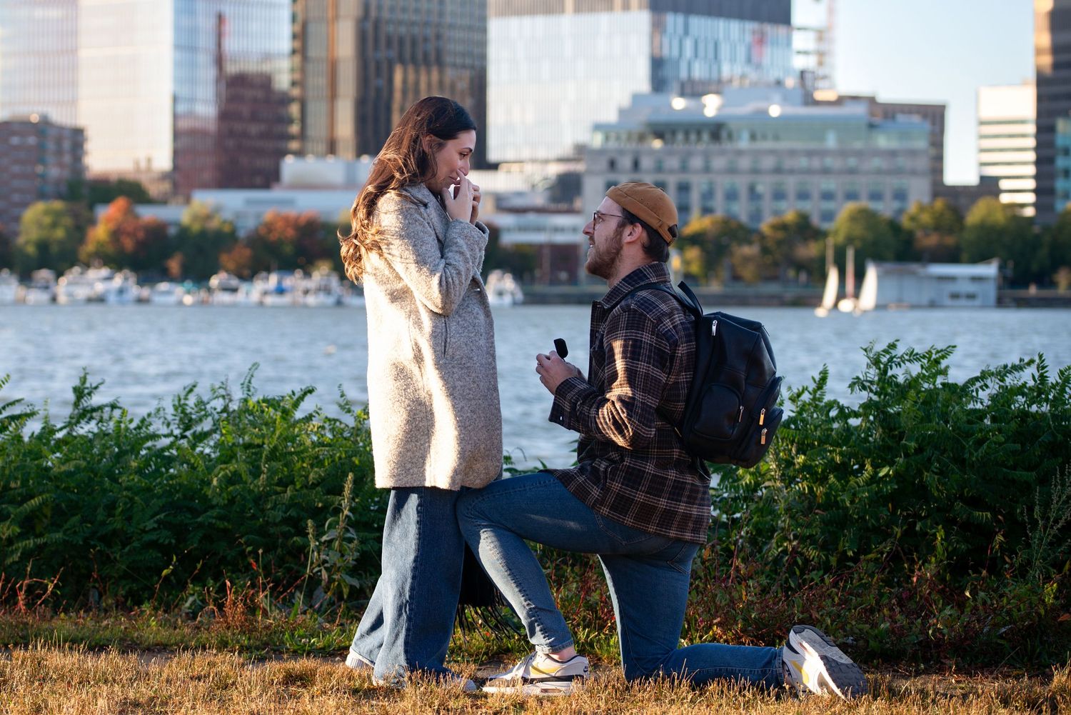 Marriage proposal on the Charles River Esplanade in Boston with views of Cambridge. Engagement captured by Leah Ramuglia Photography.