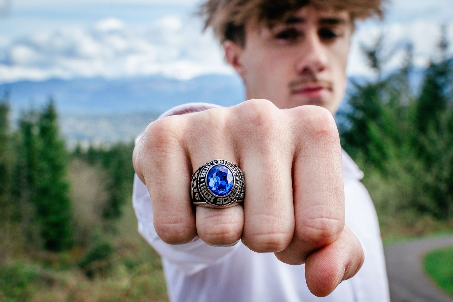 Close-up of senior boy showing class ring during portraits at Snoqualmie Point Park.
