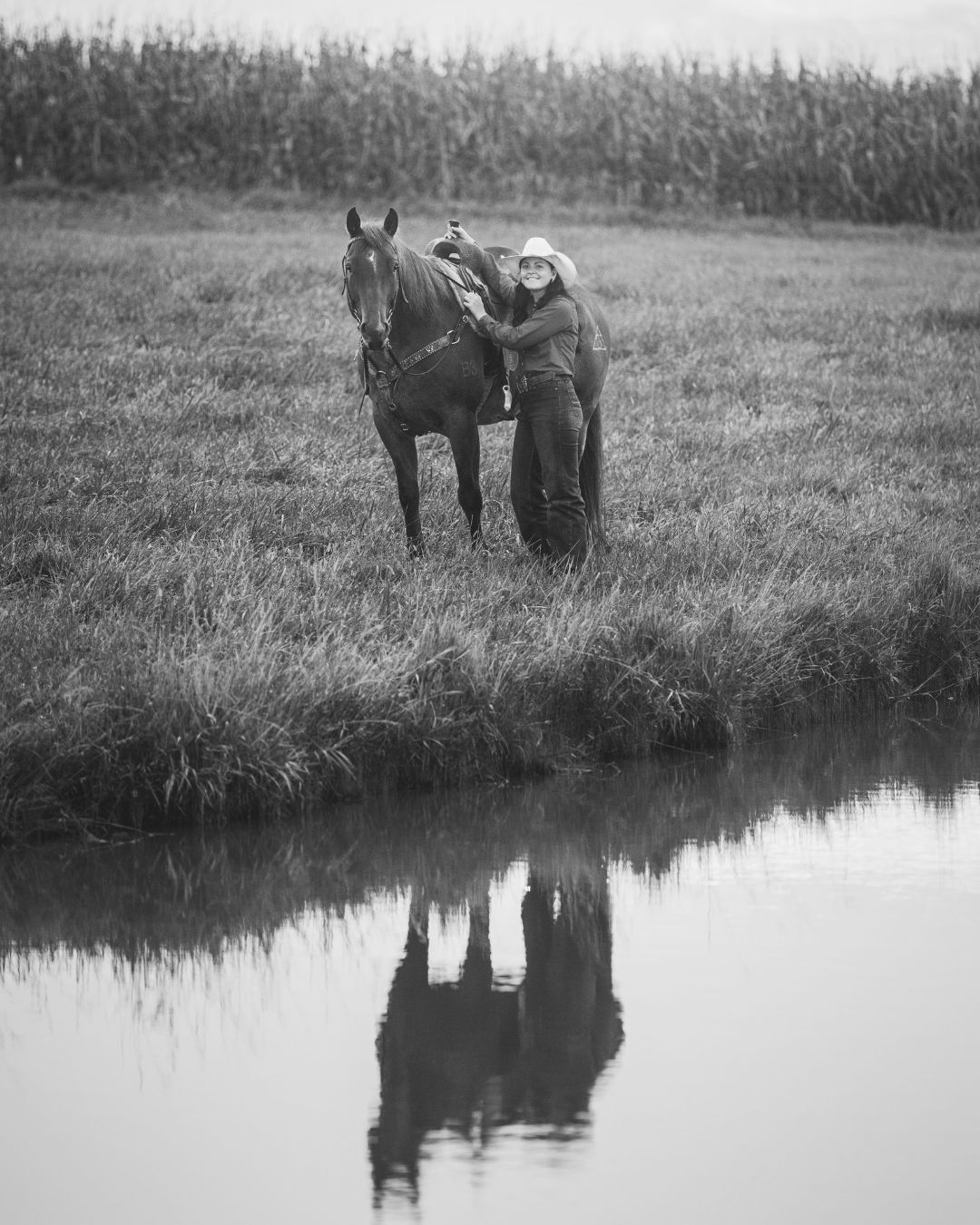 A series of black and white photos showing a horse and rider reflected in calm water by a grassy riverbank.