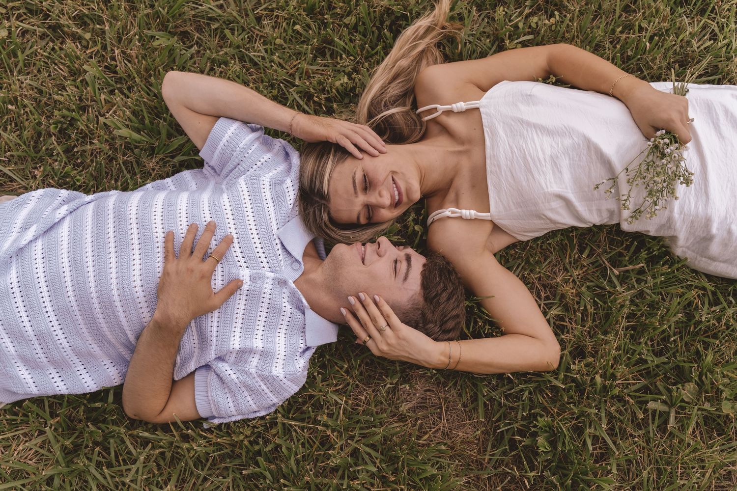 Engaged couple lying down on the grass at Willow and Stone Events in Mocksville, NC