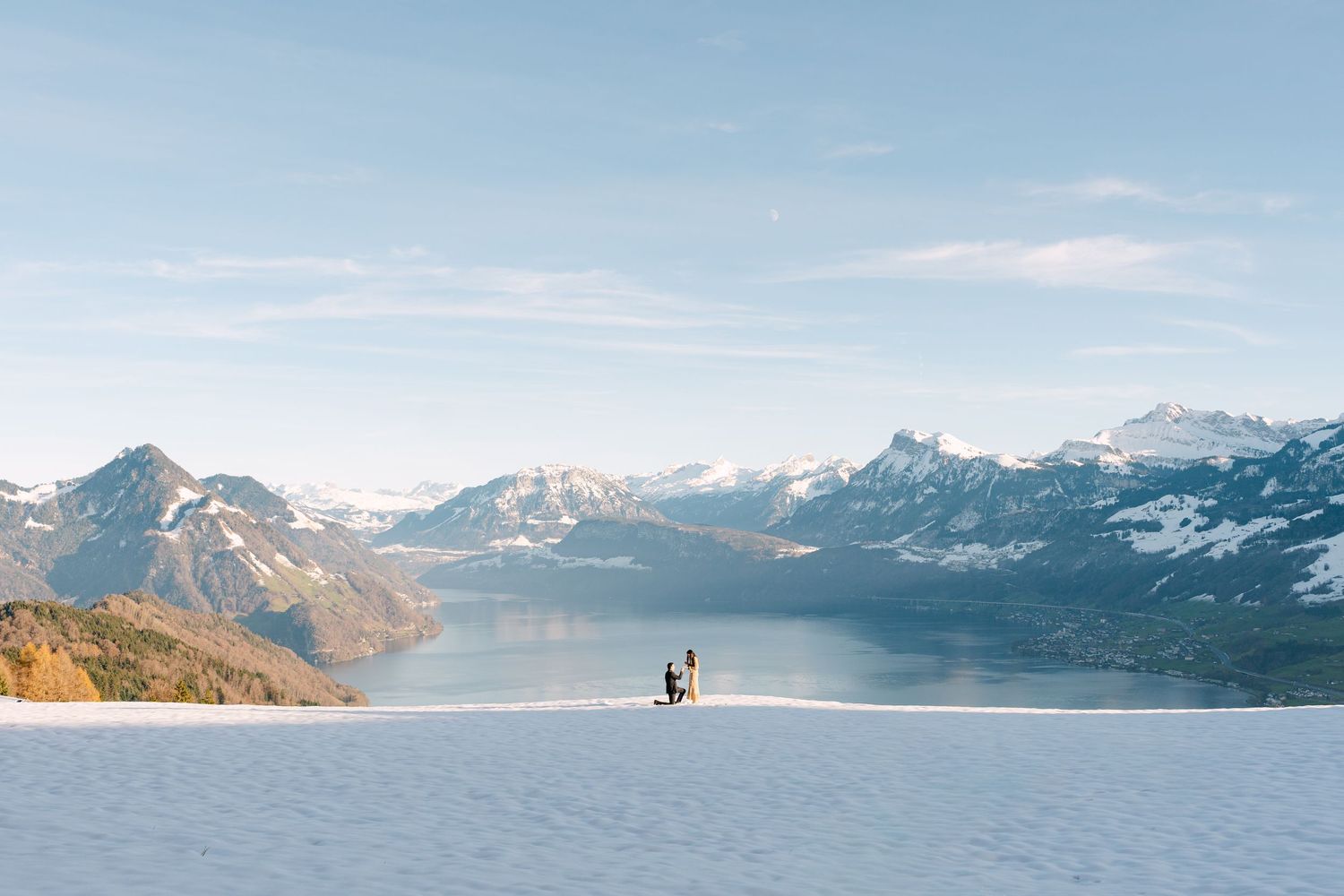 A scenic mountain landscape with snow-capped peaks and a lake reflecting the majestic alpine scenery in soft light.