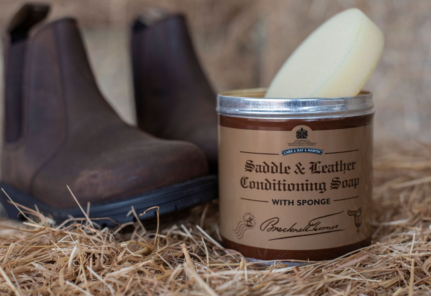product photography for saddle soap . a tin of saddle soap with some brown country boots
