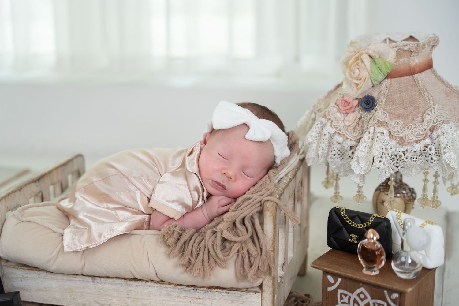 A series of photos showing a newborn baby sleeping peacefully in soft neutral-toned settings with vintage props and blankets.