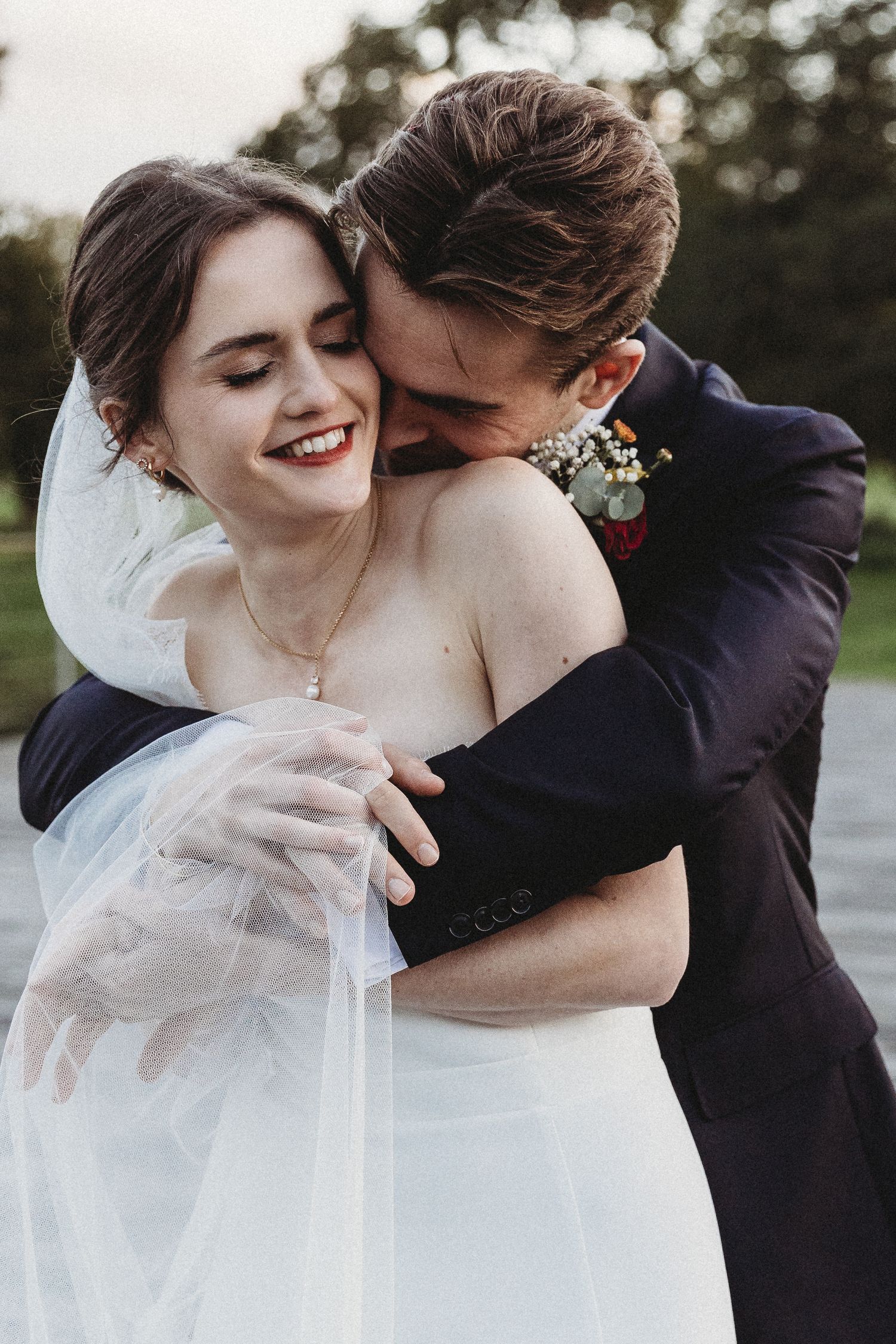 Bride and groom embrace on Latitude bridge, Henham Park