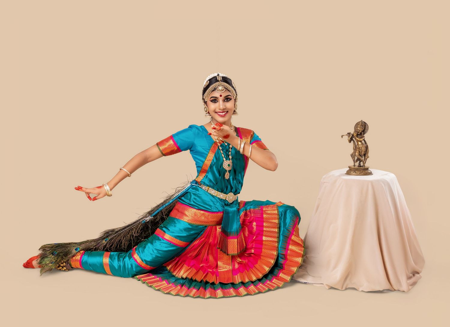 A dancer in traditional Indian attire performs a series of graceful classical dance poses against a beige backdrop.
