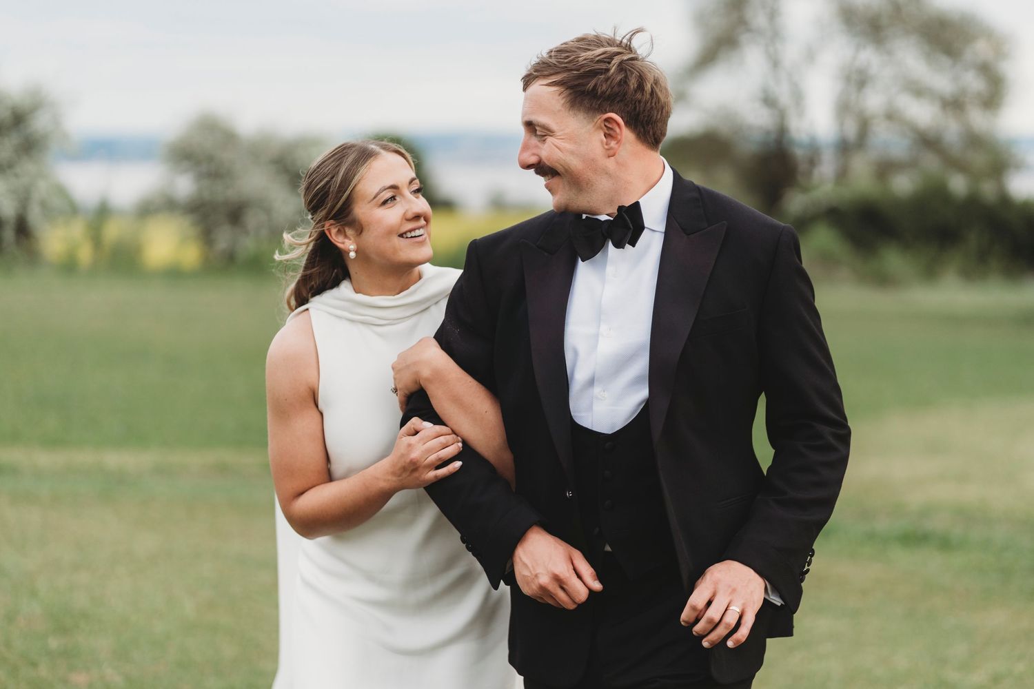 Bride and groom walking at St Tewdric's house looking at each other lovingly