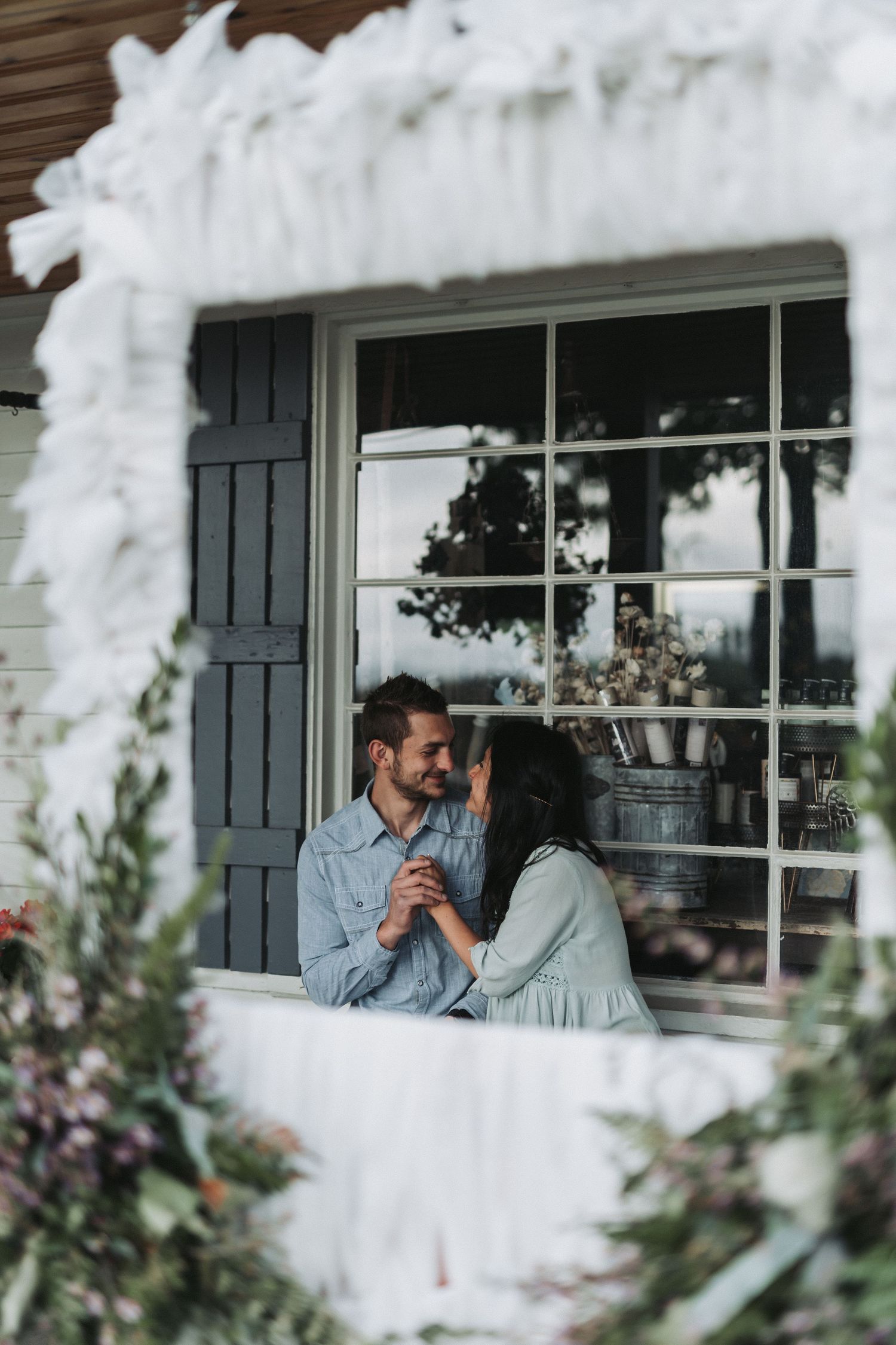 Romantic couple sharing an intimate moment through a foggy window frame.