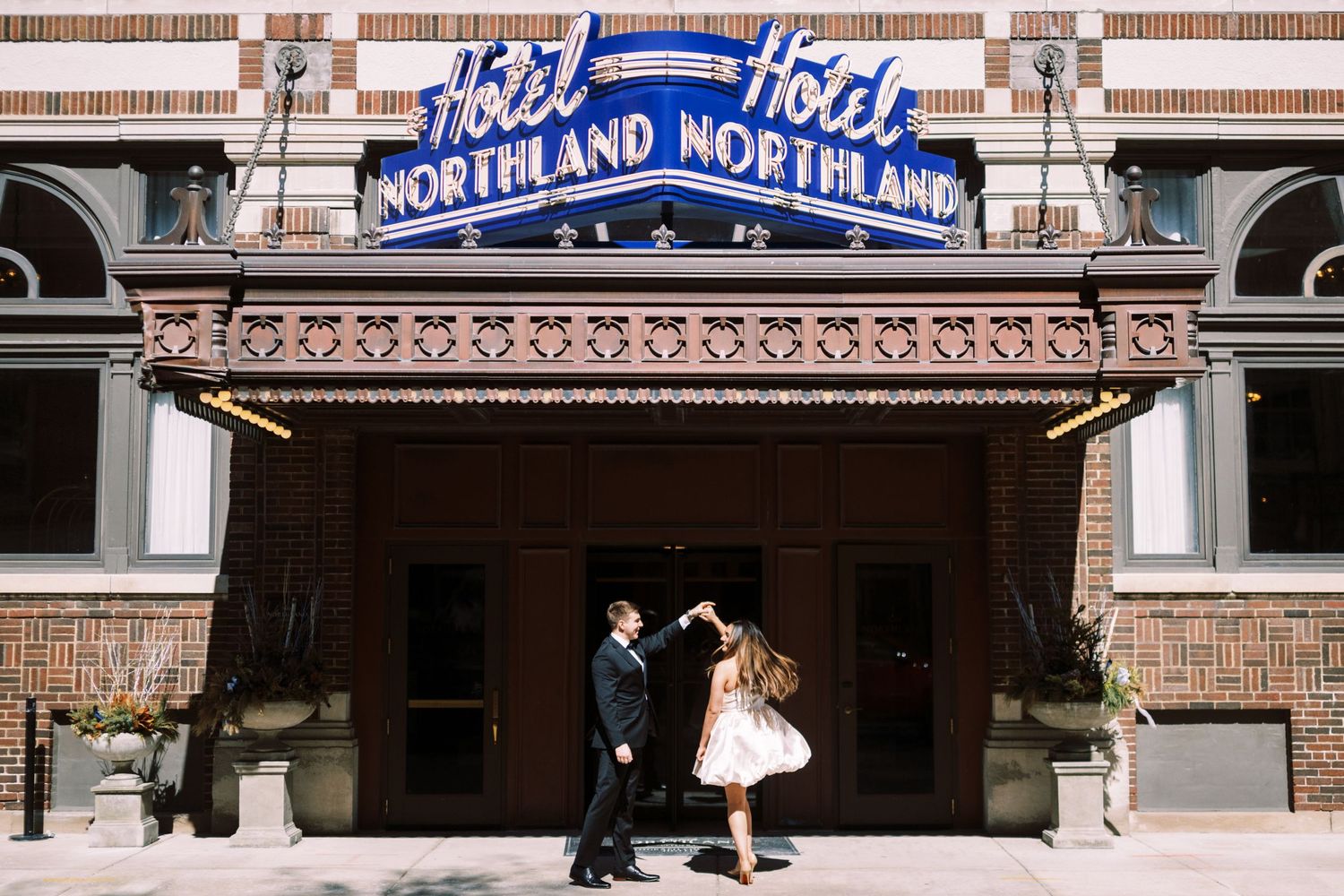 A couple dances together under the vintage blue Northland Northline theater marquee and entrance.