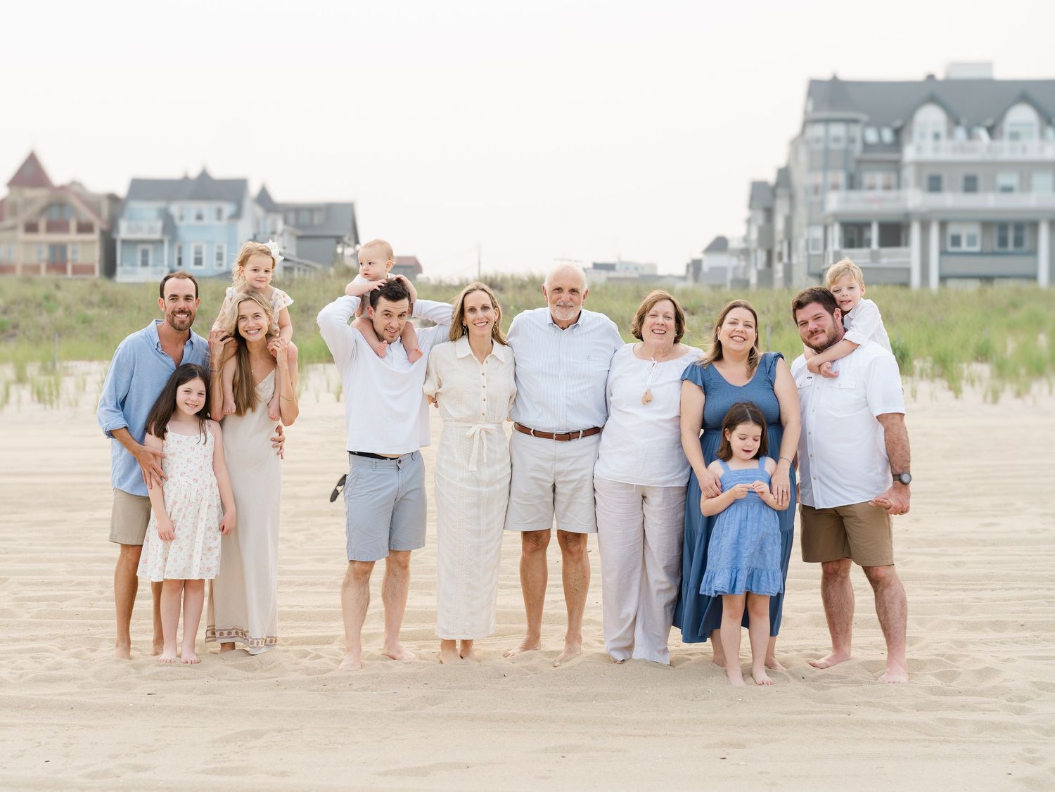 Extended family laughing together on the beach during an Ocean Grove NJ portrait session.