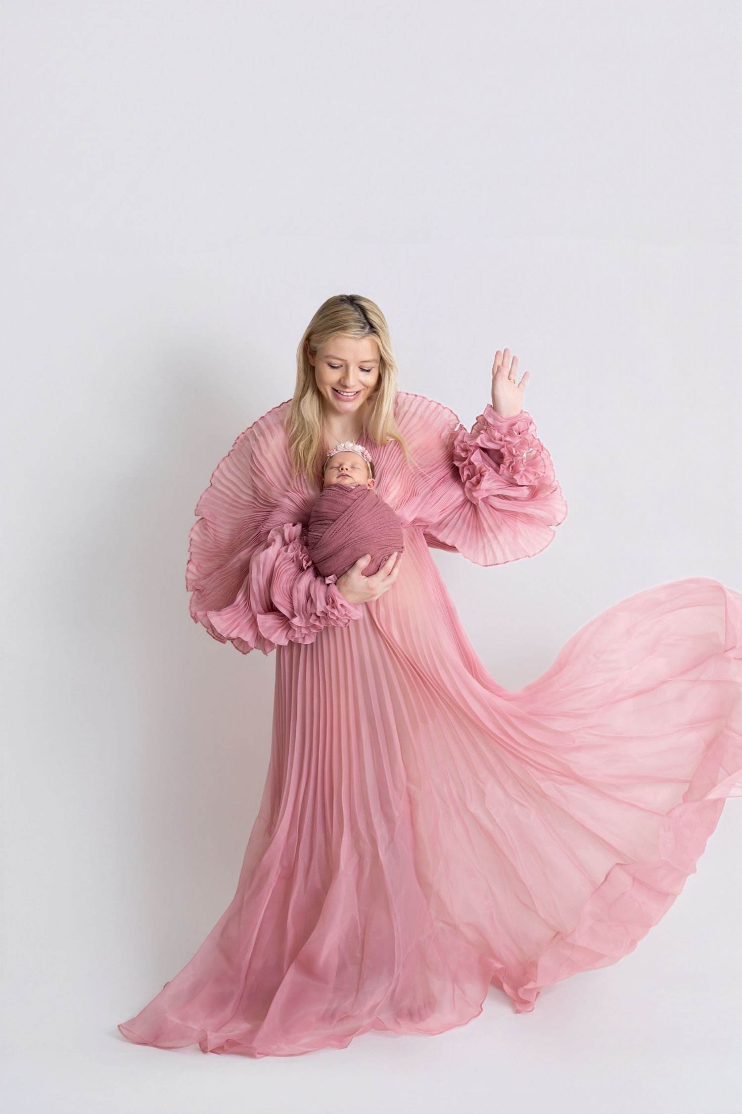 Mother holding her newborn during a natural postpartum lifestyle session, captured through newborn photography Dubai.