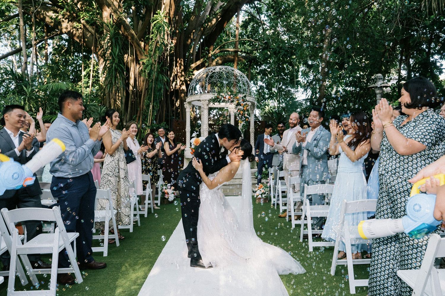 A couple shares their first dance as newlyweds under twinkling lights at an evening wedding reception.