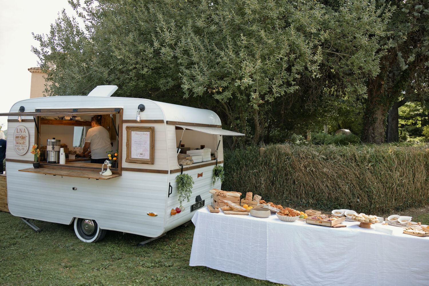 Caravane aménagée de LNA Traiteur et buffet installés en extérieur pendant une prestation.