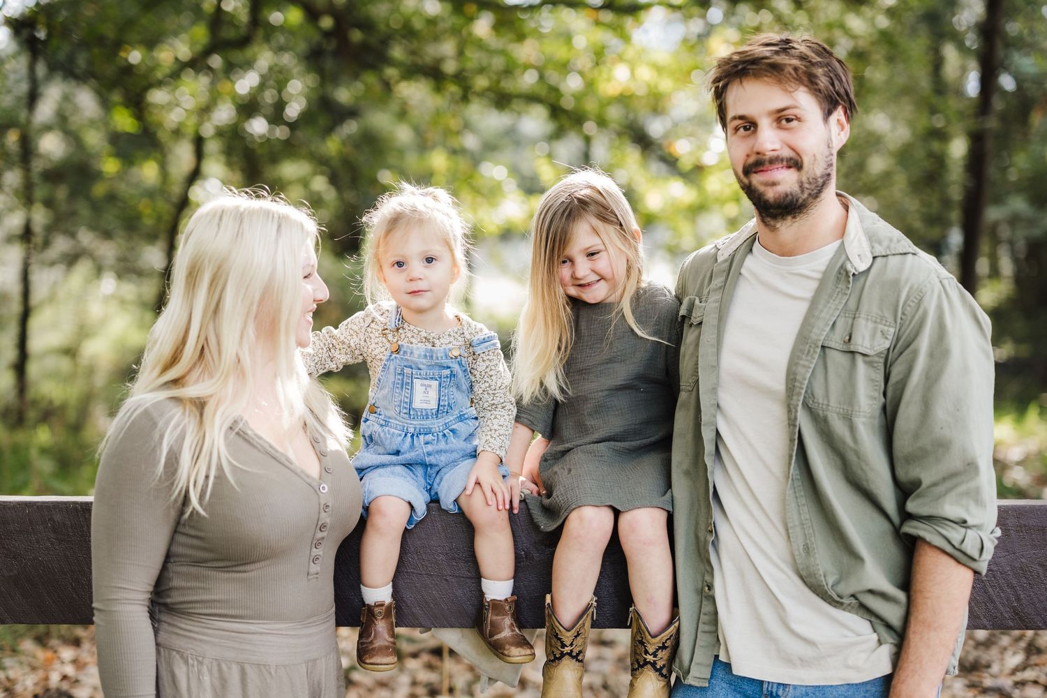 Family group poses together outdoors in casual fall attire.