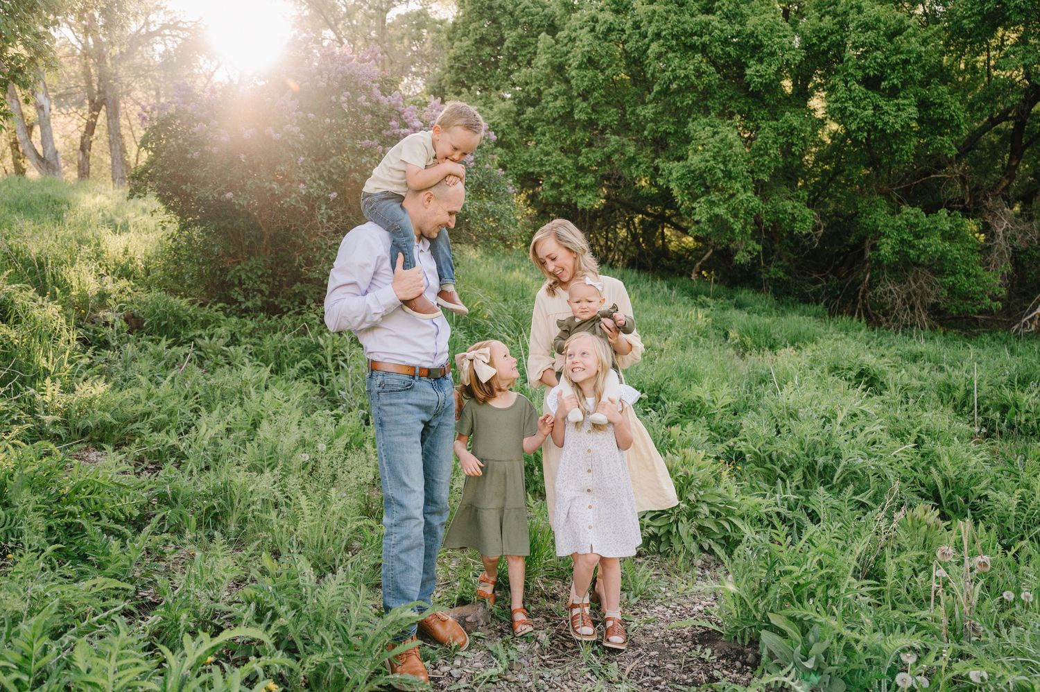 A family spending time together outdoors in a lush green garden setting at golden hour.