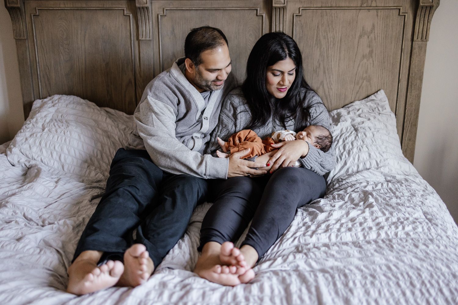 Parents hold their new baby at an in-home newborn session in San Jose with Cindy Tucey Photography