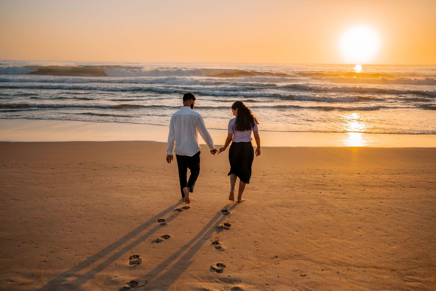 Couple walking towards the sea in Manly Northern beaches Sydney after a secret Proposal photoshoot during Sunrise