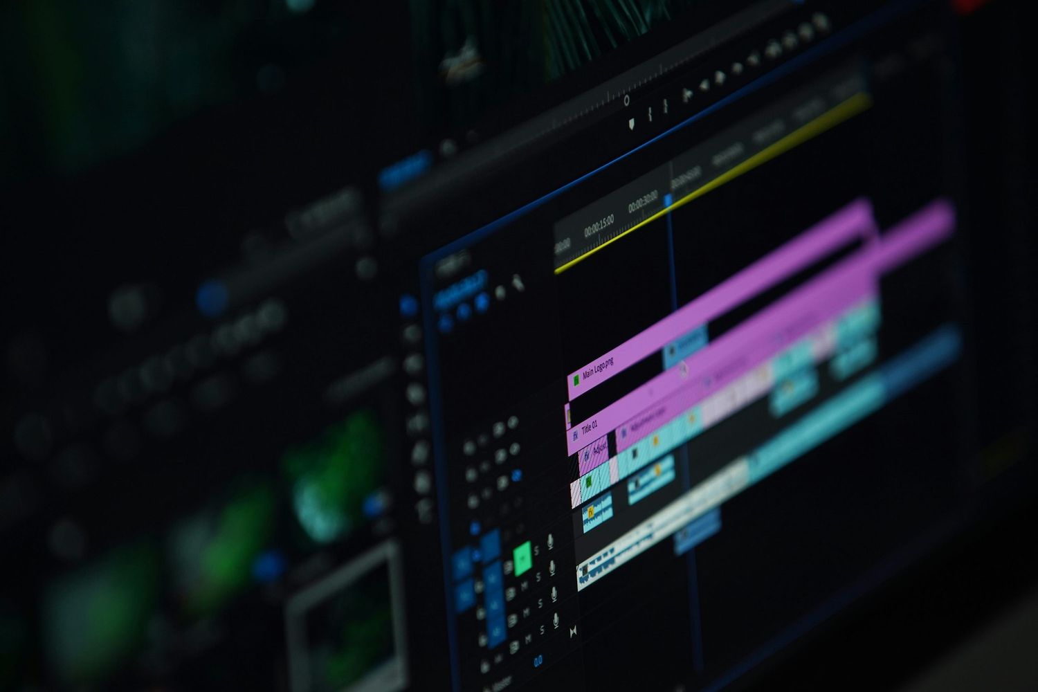 Blurred video editing timeline interface showing colorful tracks and clips in a dark editing software environment.