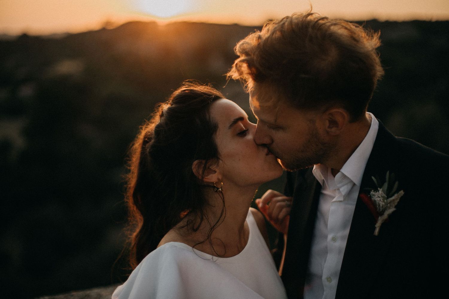 A romantic sunset wedding portrait of a couple sharing an intimate moment.