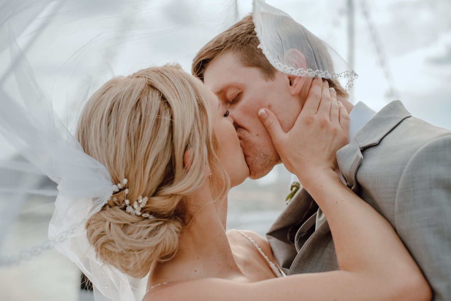 Close-up wedding moment captured with soft lighting and delicate veil details.