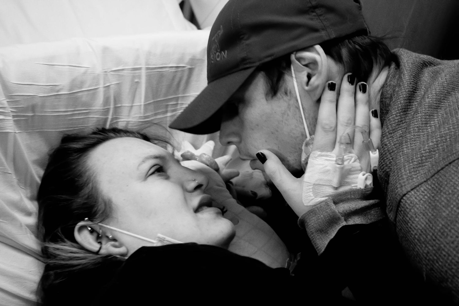 Black and white intimate captured moment between two people laying close together in candid expression.