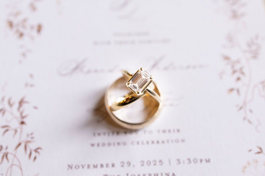 wedding rings on top of wedding invites a professional wedding image of flat lays. answering the question what to pack for your flatlays