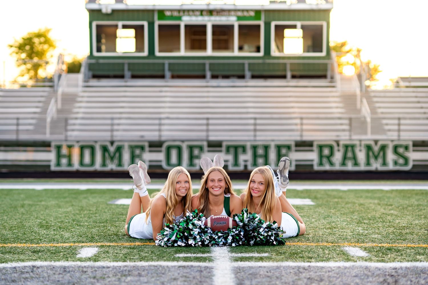 Cheerleaders perform high-energy routines in front of stadium bleachers at a spirited football game celebration.