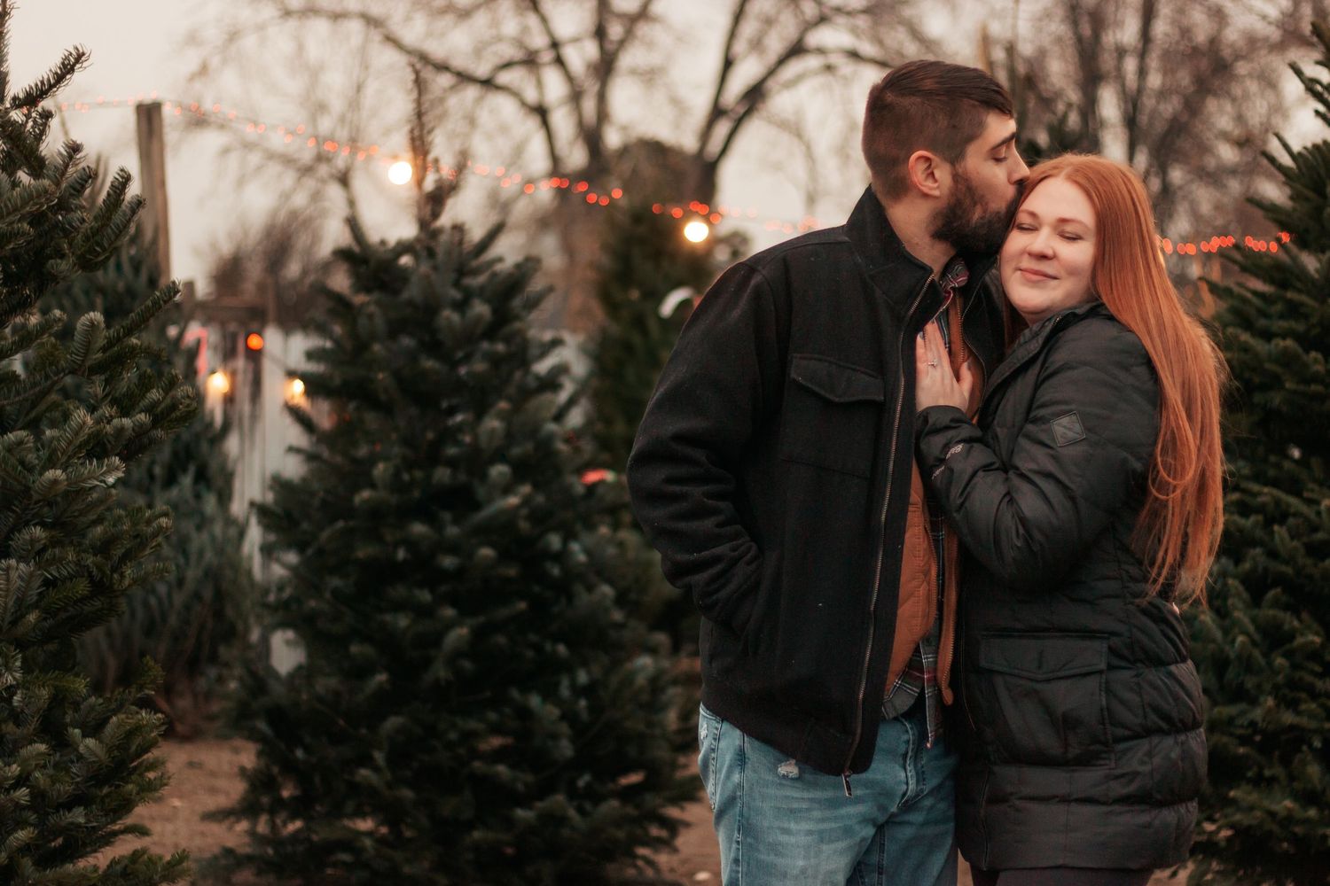 couple hugging at a tree farm after getting engaged| Westminster Colorado Proposal Photographer