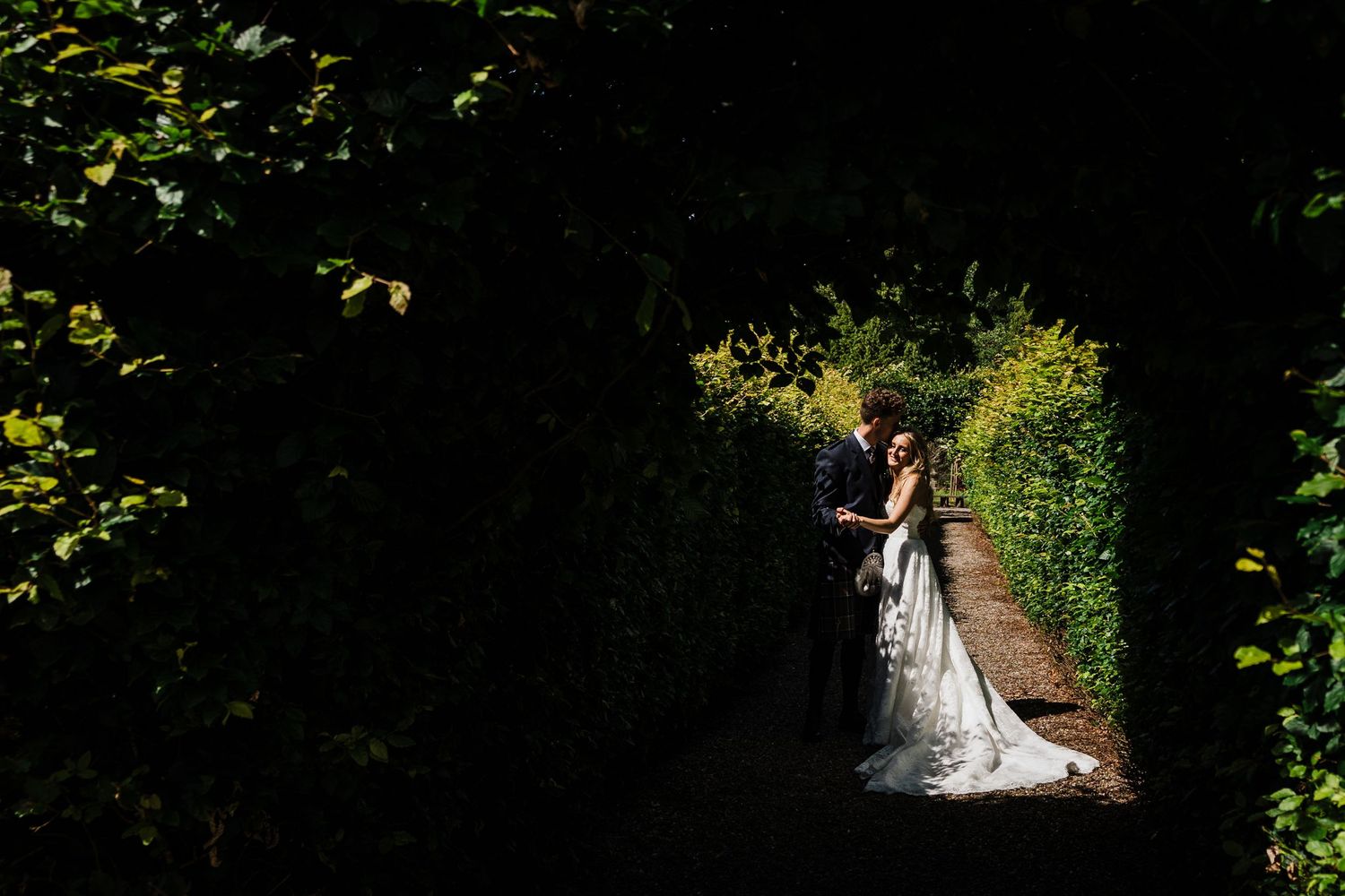 Wedding bride and groom standing in the grounds of Errol Park in Perthshire with carse of gowrie as the backdrop.  Groom is wearing a kilt.