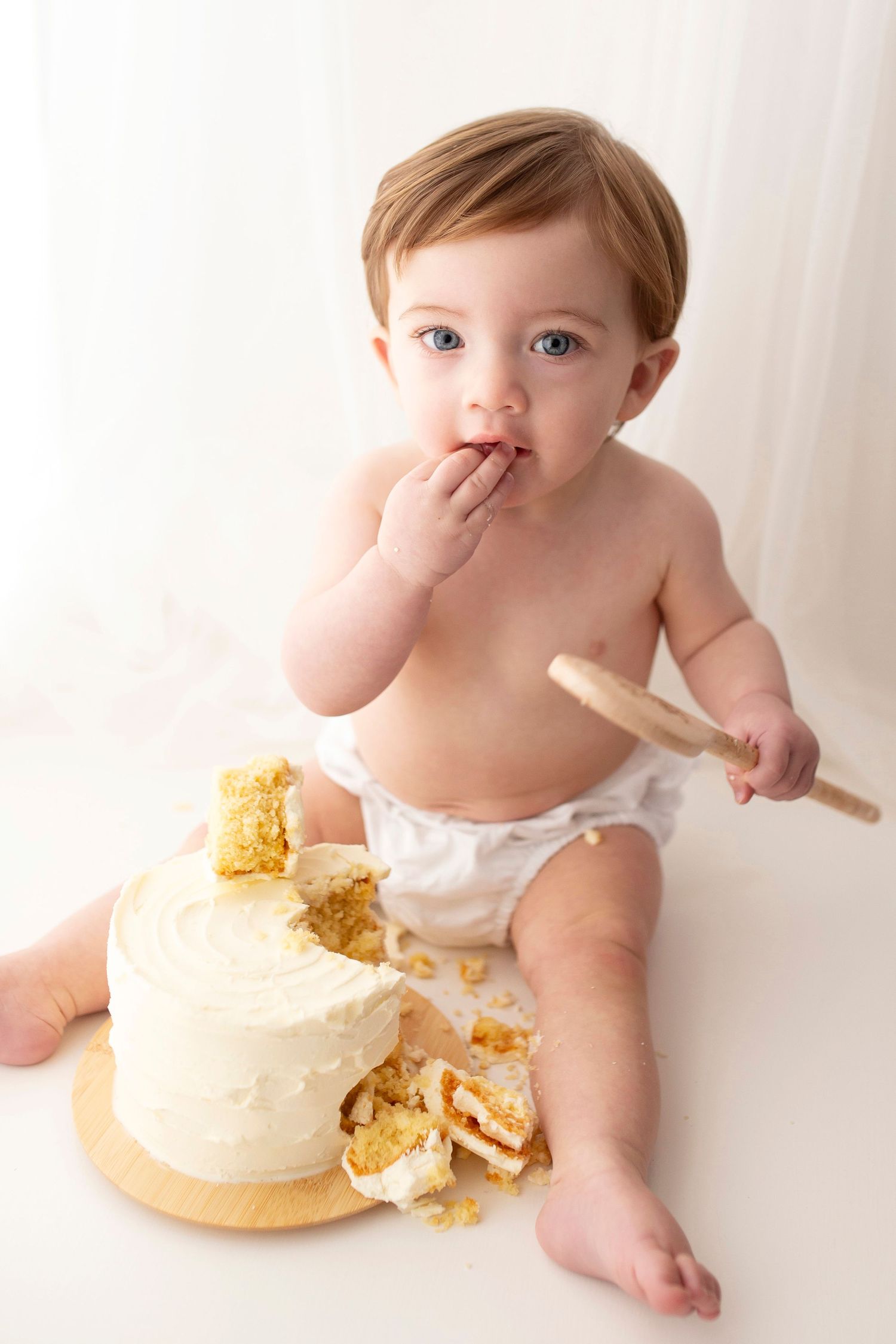 Baby eating cake during cake smash by little wonderland photography widnes cheshire