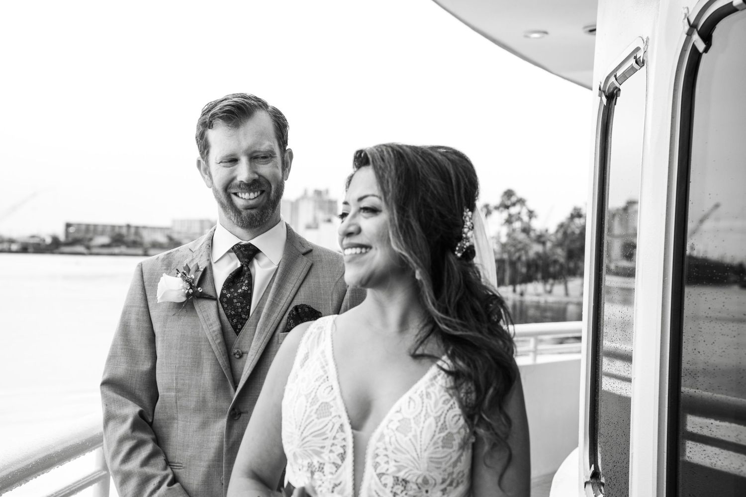 A happy couple shares a romantic moment on their wedding day while standing in a bright, sunlit doorway. Micro wedding on Yacht StarShip