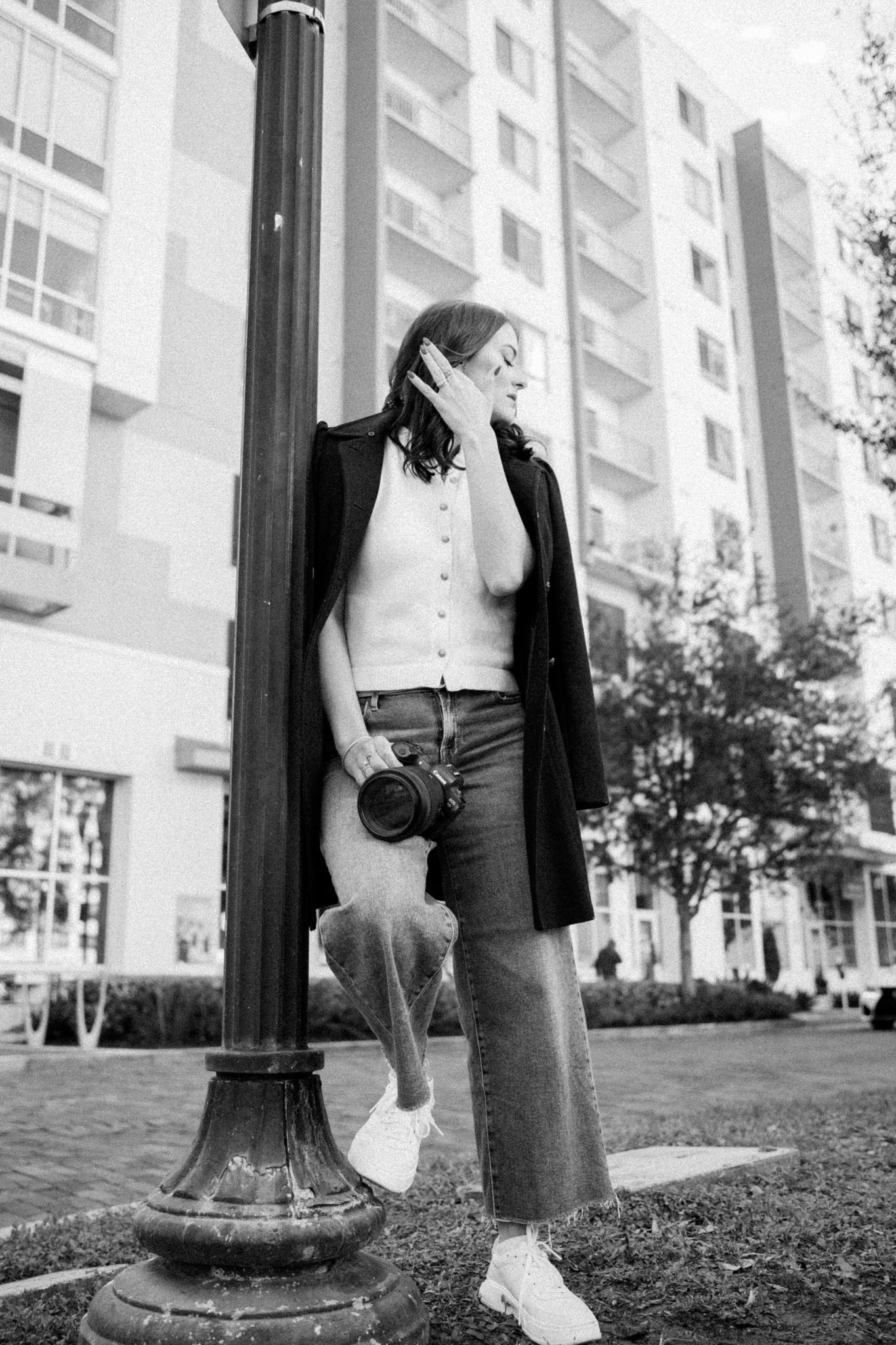 Brand photographer standing outdoors in a city holding a camera, emphasizing strategic brand photography and visual storytelling.