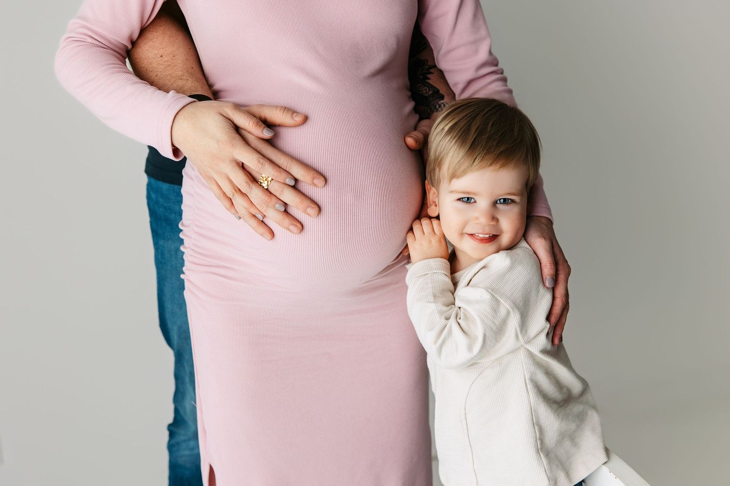 Family maternity portrait taken in Middle Tennessee, featuring expectant mother, father, and two-year-old son during a maternity session