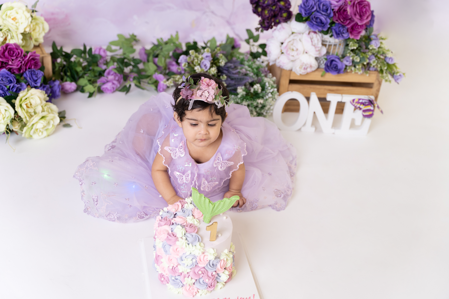 Cake smash photography Dubai session with baby safely enjoying first birthday cake in a clean professional photography studio Dubai
