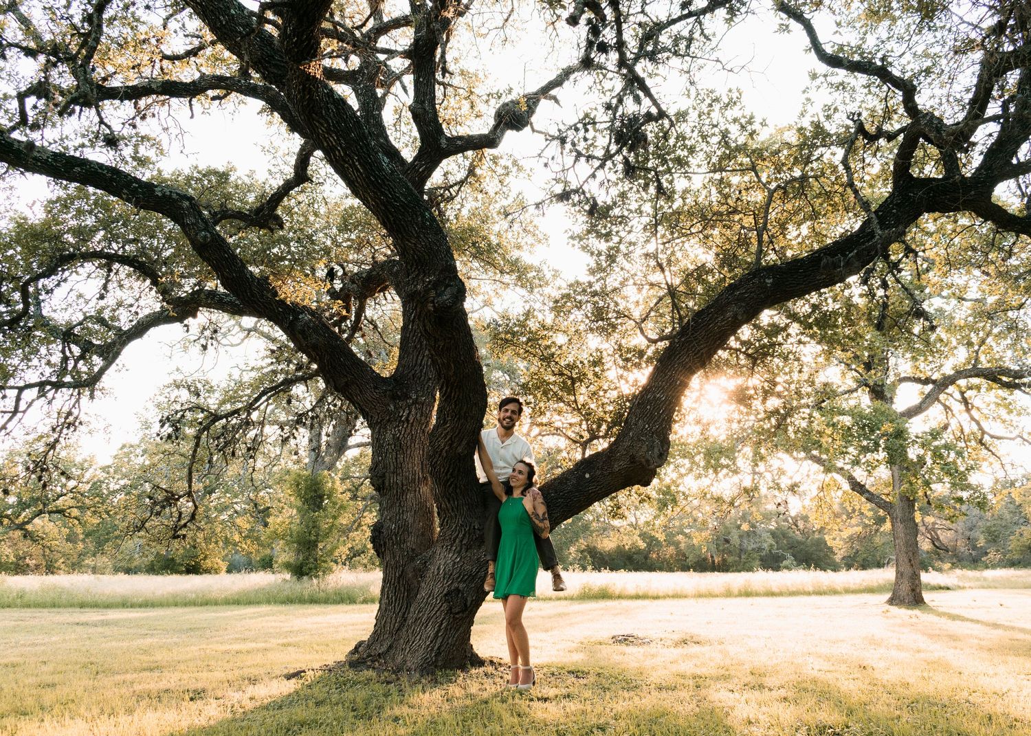Couple standing under oak tree during golden hour session with a Central Texas family photographer