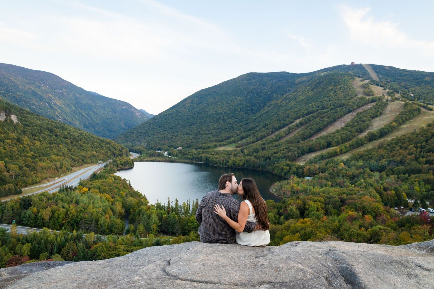 Scenic mountain views and a serene lake surrounded by lush green forests in Franconia Notch State Park, New Hampshire.