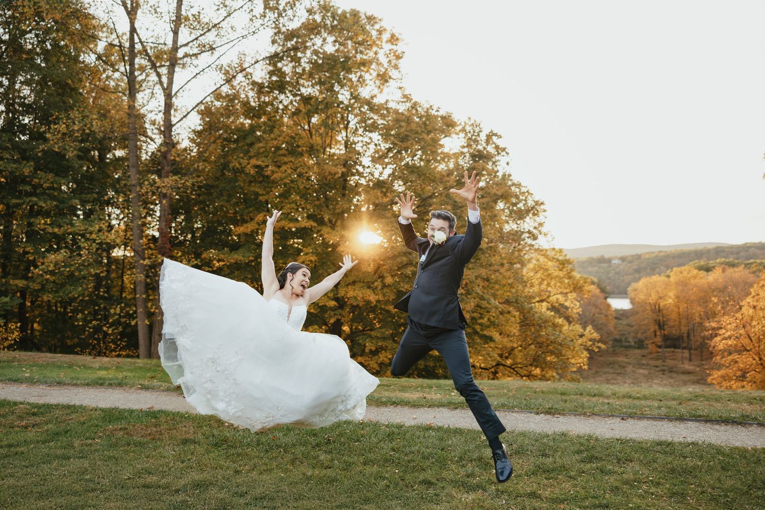 Outdoor wedding ceremony takes place on lawn in front of grand stone castle with Gothic architecture under cloudy skies.