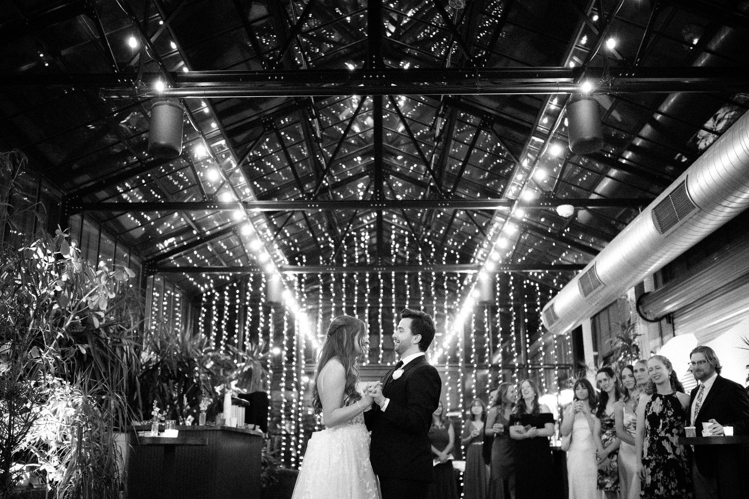 Dancing couple surrounded by elegant white pillars and grand wooden doors of a historic government building.