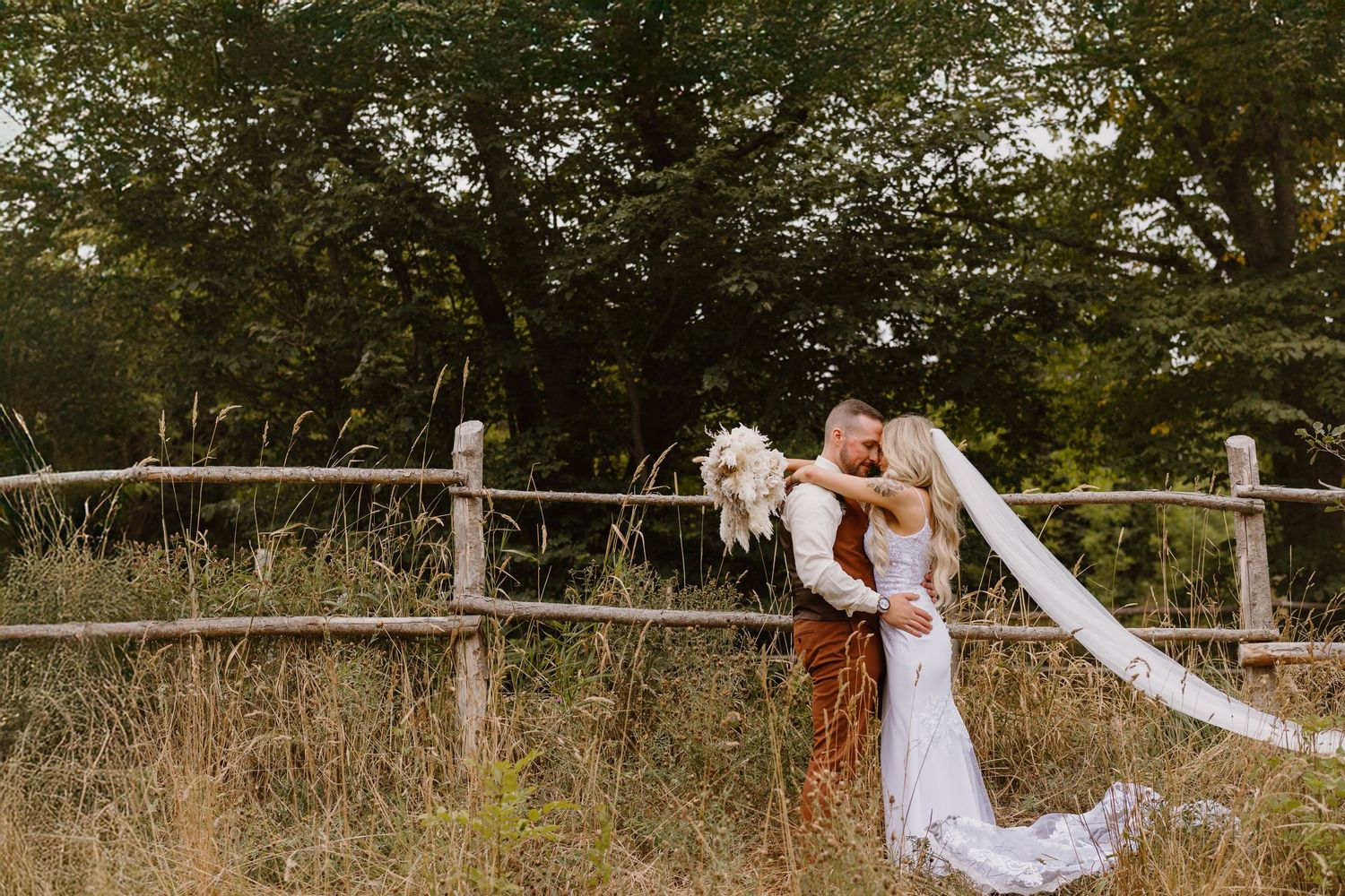 Artistic romantic wedding photography series showing a couple posing in an outdoor rustic fence setting at sunset.