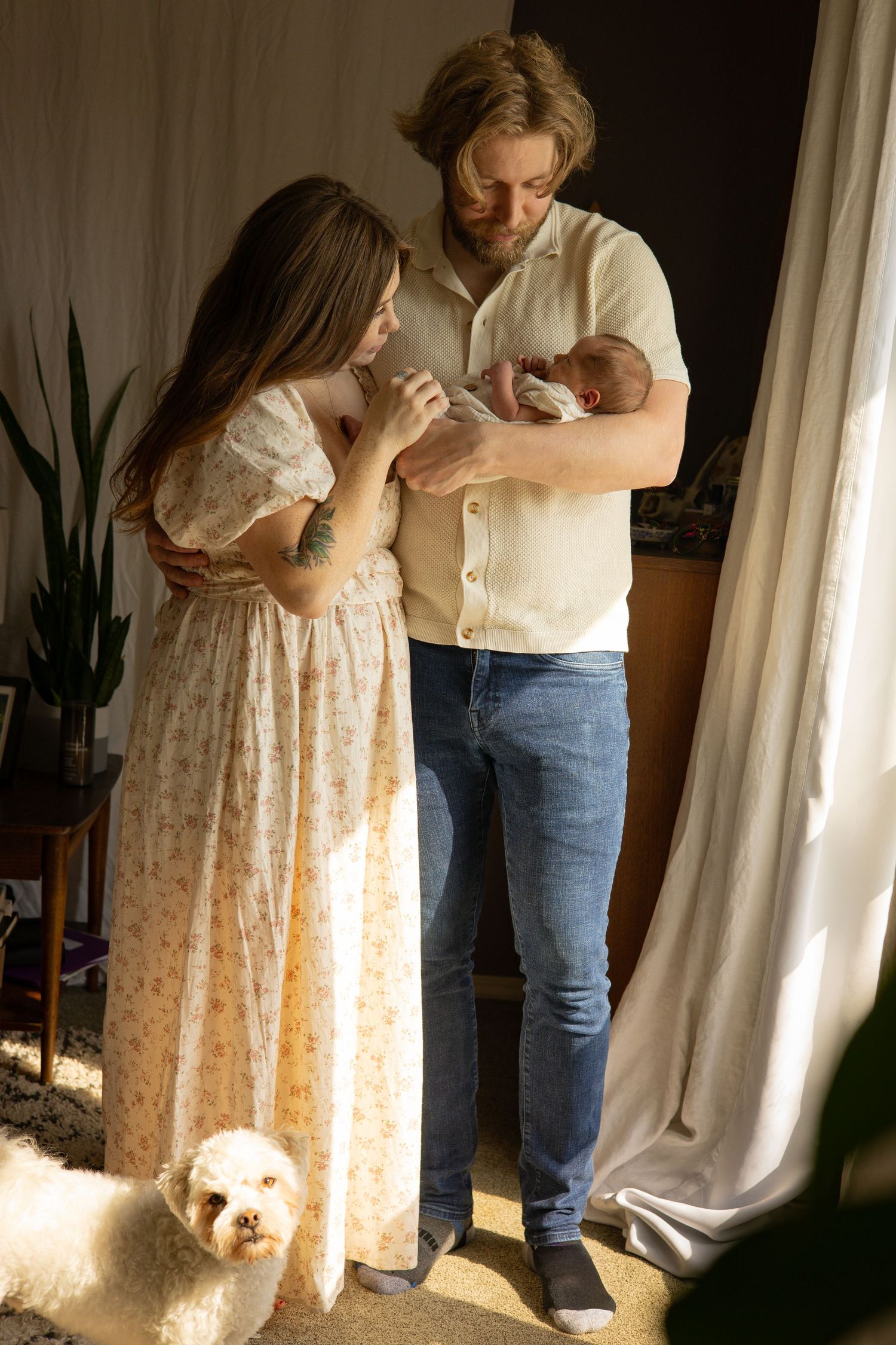 A series of tender moments between parent and newborn baby in a sunlit room with white curtains. Lifestyle Family Photography Tacoma WA