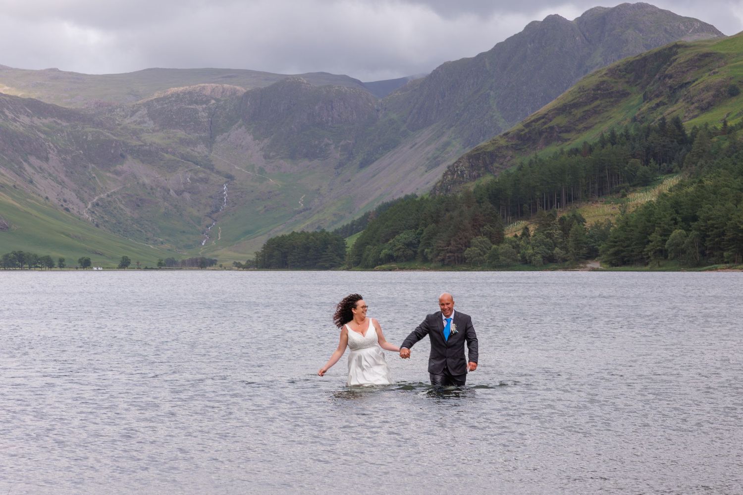 Panoramic sequence of mountain peaks and valleys surrounding a tranquil lake in the Scottish Highlands.