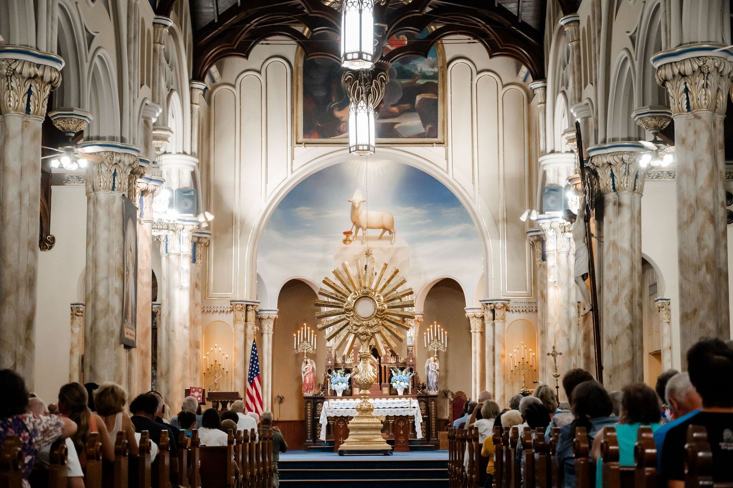 Interior panorama of ornate church sanctuary with vaulted ceilings and religious artwork.