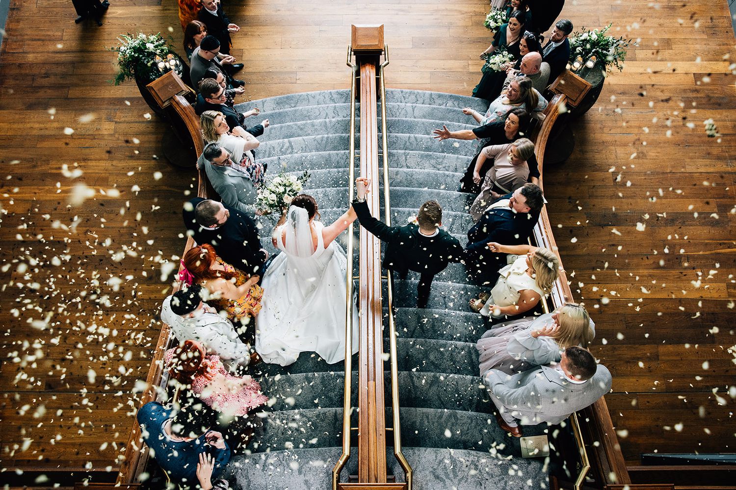 Confetti rains down on a couple during their first dance at an elegant indoor wedding reception.