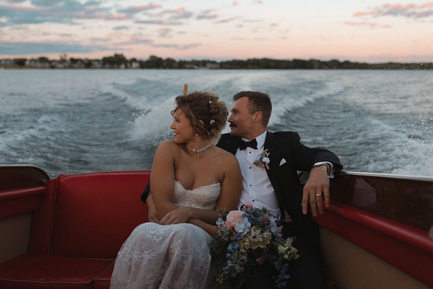 Couple enjoying a romantic boat ride during sunset on calm waters.