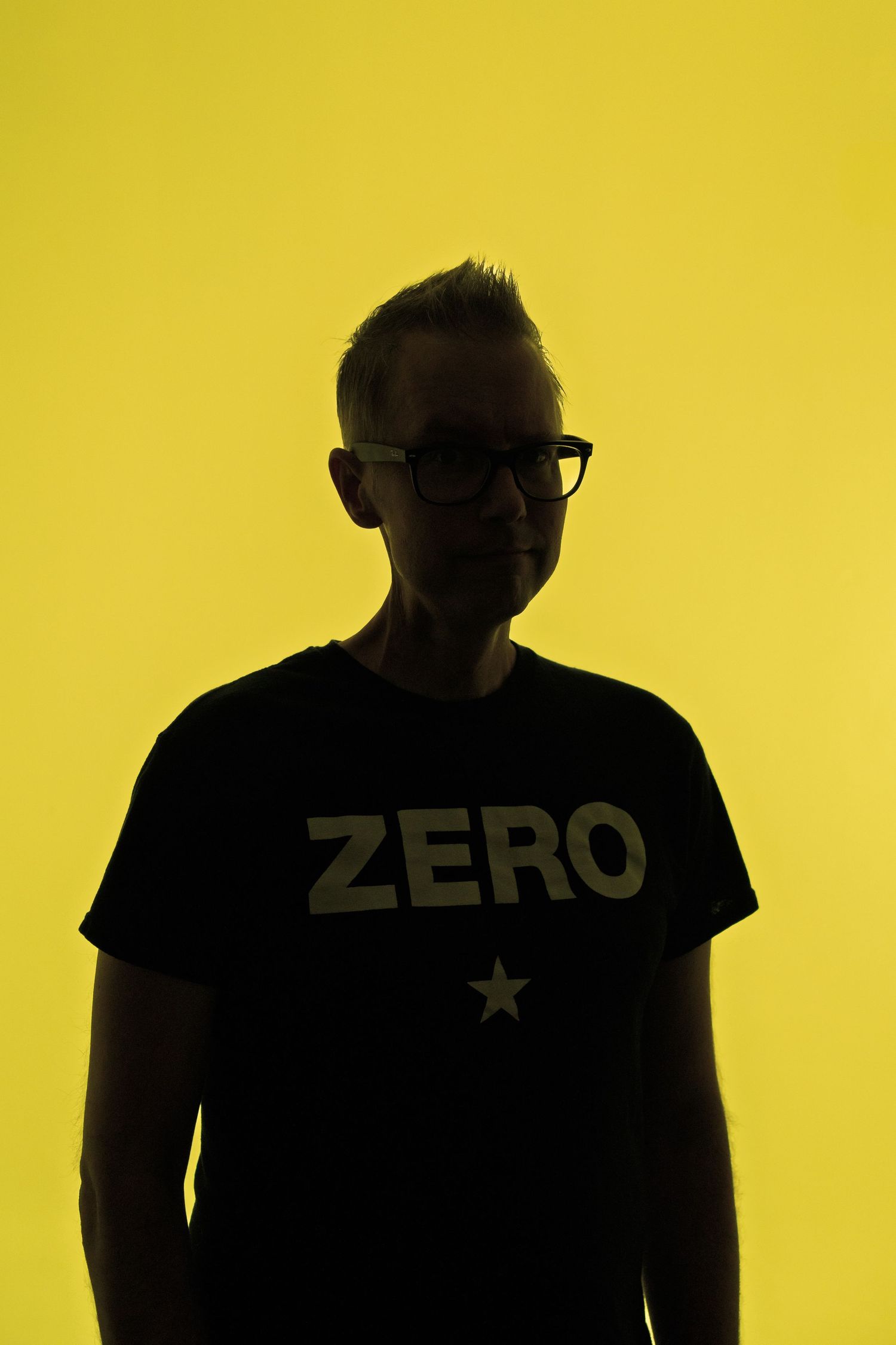 A series of five images showing a person in a blue striped shirt adjusting their glasses against a gray background.